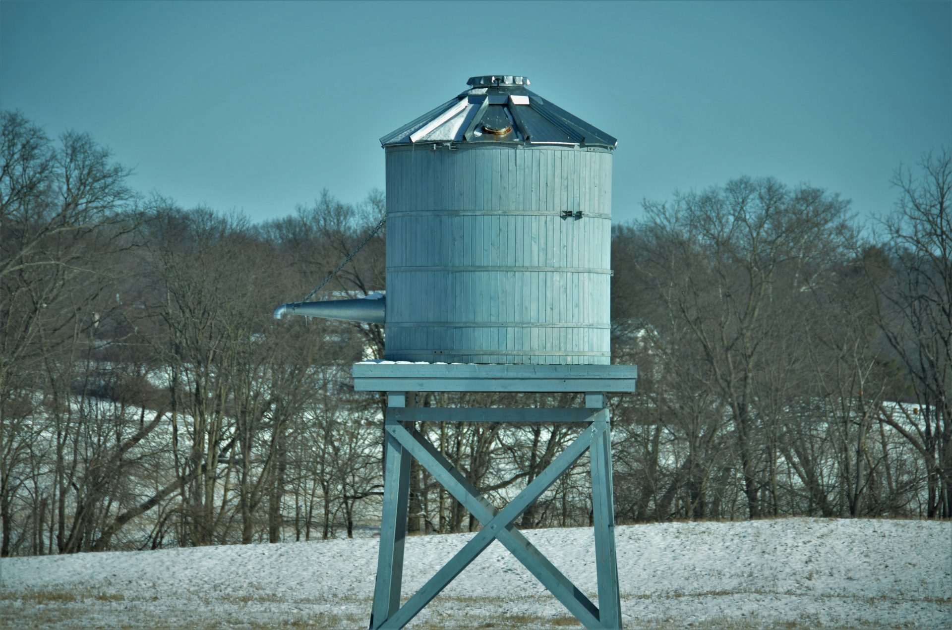 a large metal silo sitting in the middle of a field